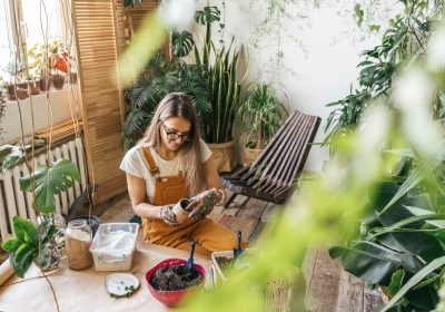 Young woman working with soil in a small gardening shop Young woman working with soil in a small gardening shop